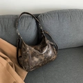Retro distressed dark brown hobo shoulder bag with silver hardware on a sofa - Coffee