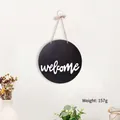 Dettaglio di una targa rotonda welcome in legno nero con corda, peso di 157g - Stile Disco Nero Welcome