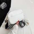 White lychee leather crossbody bag with geometric woven strap and tassel detail - White