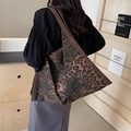 Stylish large capacity leopard print canvas tote bag shown on model in a cozy room - Brown