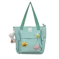 Mint green nylon tote bag featuring cute star patches and a white plush charm accessory - Green