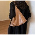 Warme bruine kunstlederen shopper met geplooide textuur getoond op een model - Tan