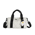 White quilted nylon cylinder handbag with black straps and astronaut plush keychain detail - White