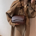 Elegante borsa a spalla in pelle marrone scuro con patta curva e dettagli dorati - caffè