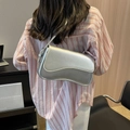 Silver metallic crossbody bag with asymmetrical flap shown on a model in casual attire - Silver