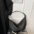 Detail of black pebbled leather hobo bag on a silver suitcase with minimalist design - Black