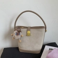 Détail du sac seau en daim beige avec garniture en cuir marron et fermoir en métal doré - Abricot