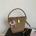 Détail d'un sac seau marron vintage avec fermoir doré et breloque ours en peluche mignon - Marron