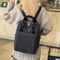 Minimalist black commuter backpack with white rabbit logo and premium textured fabric - Black