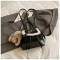 Detail view of mini black leather backpack with white fur trim and cute rabbit pendant - Black With Pendant