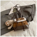 Detail of a patchwork backpack with faux shearling trim and a plush rabbit charm - Brown with Pendant