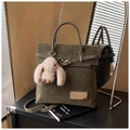 Vue détaillée du sac à dos vintage vert olive avec breloque lapin et badge métallique - Vert avec Pendentif