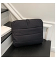 Macro detail of the black quilted fabric texture and zipper on the laptop clutch bag - Black