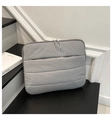 Detail of grey quilted laptop sleeve with waterproof texture and front zipper pocket - Gray
