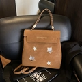 Brown matte backpack with star patches and woven rope handle on a black sofa - No Pendant / Brown