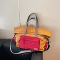 Ginger and dark red nylon travel tote bag with adjustable grey strap on a sofa - Brown