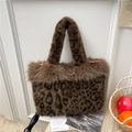 Faux fur leopard print tote bag with plush brown handles on a cozy rattan chair - Brown