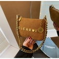 Detail showing the gold metal letters and thick chain on a brown suede shoulder bag - Brown
