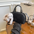 Detail of black lamb fleece bucket bag with leather brand tag and grey bunny charm accessory - Black With Pendant