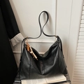 Detail of a black leather tote bag featuring a decorative wooden bead tassel accent - Black