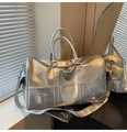 Detail of silver metallic travel bag showing crinkled texture and reinforced handles - Silver
