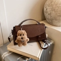 Dunkelbraune matte quadratische Handtasche mit Plüsch-Hundeanhänger am Koffer - Kaffee mit Anhänger