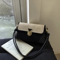 Détail du sac bandoulière bicolore avec fermoir métallique doré et textures contrastées - Noir