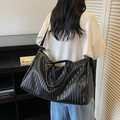 Large black woven travel bag with PU leather texture shown on shoulder for gym and travel - Black