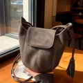 Sac seau minimaliste gris-brun avec surpiqûres blanches et détail de pompon élégant - Café