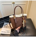 Vue détaillée du sac seau en daim marron avec bordure en peluche blanche et perles en bois - Marron