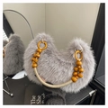 Detailed macro view of the fluffy faux fur texture and yellow wooden bead handle on the grey bag - Gray