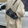 Retro black leather underarm bag with silver square buckles worn with a trench coat - Black