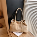 Borsa tote minimalista in camoscio beige con manici sottili su tavolo in legno - Cachi