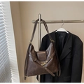 Detail of vintage dark brown faux leather tote with golden hook on metal display rack - Coffee No Charm