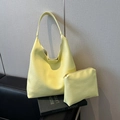 Hobo-Tasche und Beutel-Set aus zitronengelbem Leder mit Kieselmaserung auf Büchern - Gelb