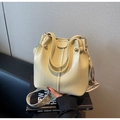 Détail du sac seau jaune à motif crocodile avec une large bandoulière tissée géométrique - Jaune