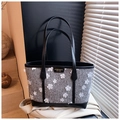 Detail der grauen Tweed-Tasche mit 3D-Blumen-Dekor und schwarzen Lederbesätzen - Grau