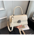 Close-up of cream-colored glossy leather handbag with silver metallic twist-lock closure - Off White