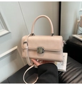 Detailansicht einer cremefarbenen Lederhandtasche mit Silberverschluss und Griff - Rosa