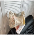 Detail view of beige canvas bucket bag with Chinese embroidery and yellow tassel - White
