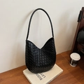 Sac bandoulière en cuir tressé noir minimaliste avec anse ronde sur livres blancs - Noir