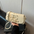 Chic cream-colored shoulder bag with corset-style lace-up detailing and silver eyelets - White