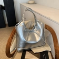 Metallic silver PU tote bag with delicate bow detail on a stylish wooden chair - Large / Large Silver