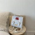 Dettaglio dello zaino a quadretti blu con ricamo a mela rossa e scritta Not Anxious - Bianco