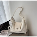 Detail of a creamy white tote bag with star ornament, rivets, and a plush cloud charm - Off-white