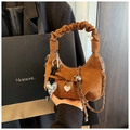 Detail einer braunen Wildledertasche mit gerafftem Griff, Metallkette und Marmor-Anhängern - Braun