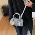 Silver cylinder bag with marble print and heart mirror charm on a black blazer - Silver