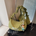 Grasgrüne gefaltete Canvas Halbmondtasche mit Puppenanhänger und Markenlogo - Grün mit Anhänger