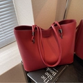 Chic brick red tote bag in litchi grain leather with dual handles and gold logo detail - Red