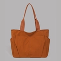 Detail der karamellfarbenen Nylon-Tragetasche mit Seitentaschen und breiten Trägern - Orange